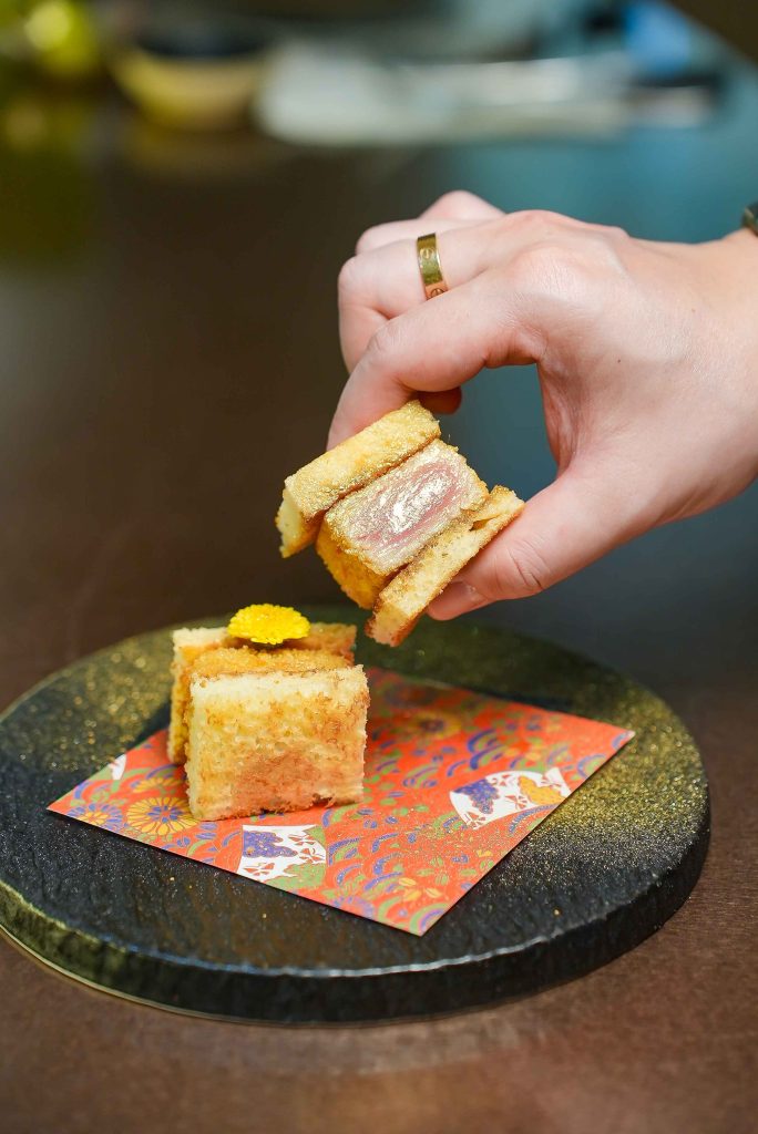 A toast course lifted from a black lacquer plate